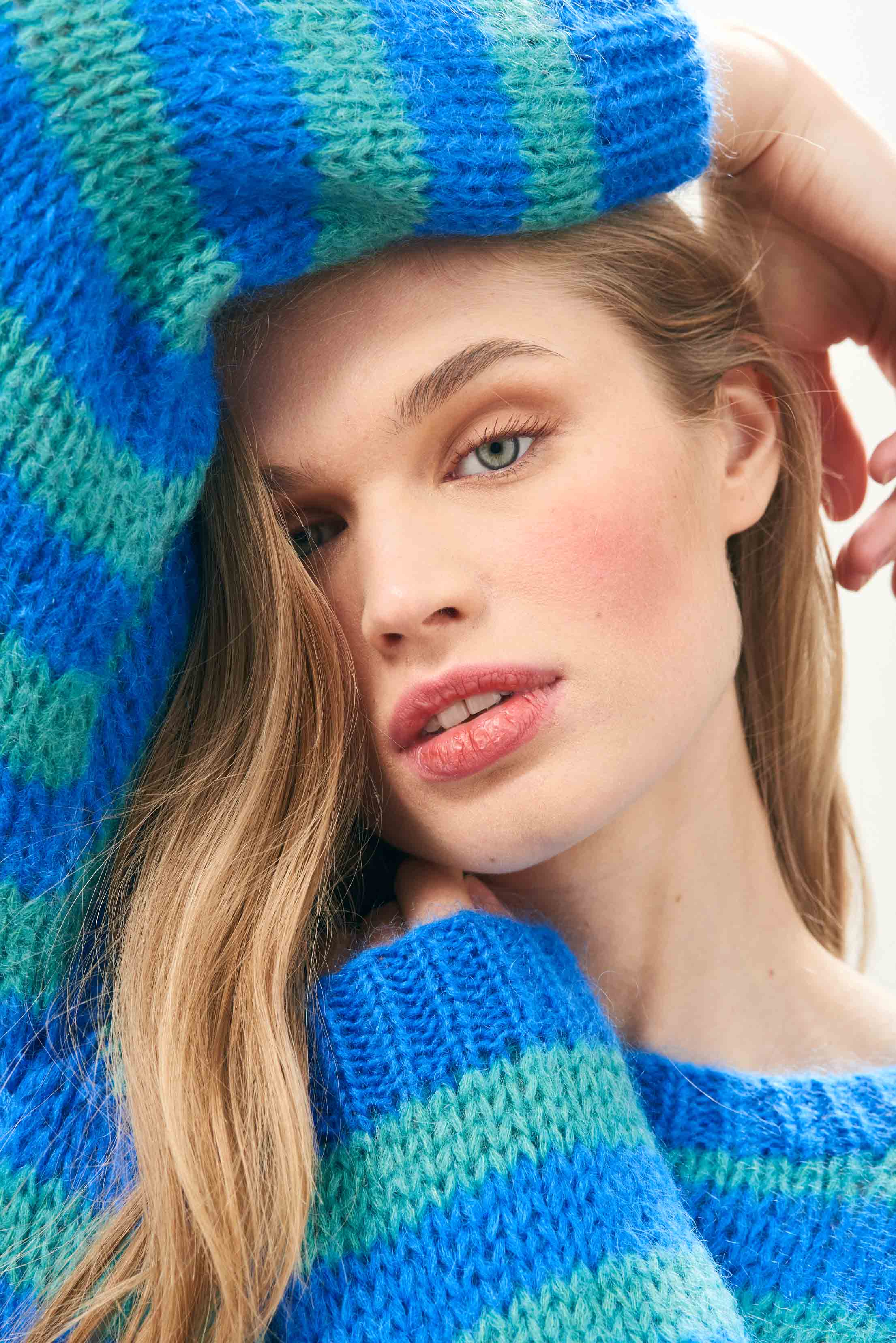 Female model wearing Jumper 1234 hand knitted mohair and wool blend hand knitted crew neck jumper in blue and green stripes close up.