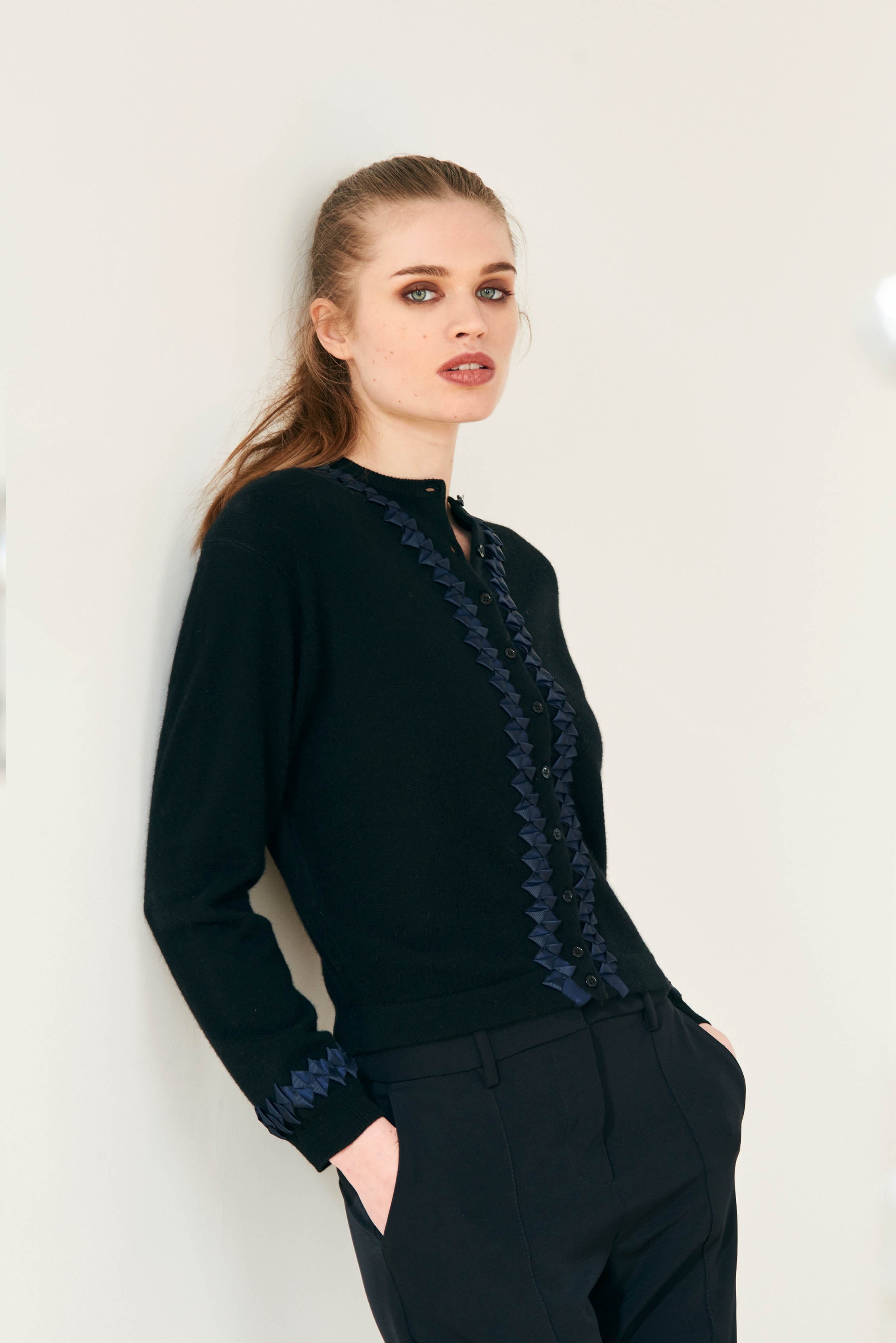 Female model wearing Jumper 1234 cashmere wool neat fit crew neck cardigan in black with navy twisted ribbon detail