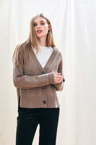 Female model wearing Jumper 1234 cashmere wool mid brown oversize vee neck cardigan with Guernsey details, splits at the sides and it's slightly longer at the back