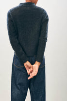 Female model wearing Jumper1234 Cashmere Brushed Turtle in Black facing away from the camera