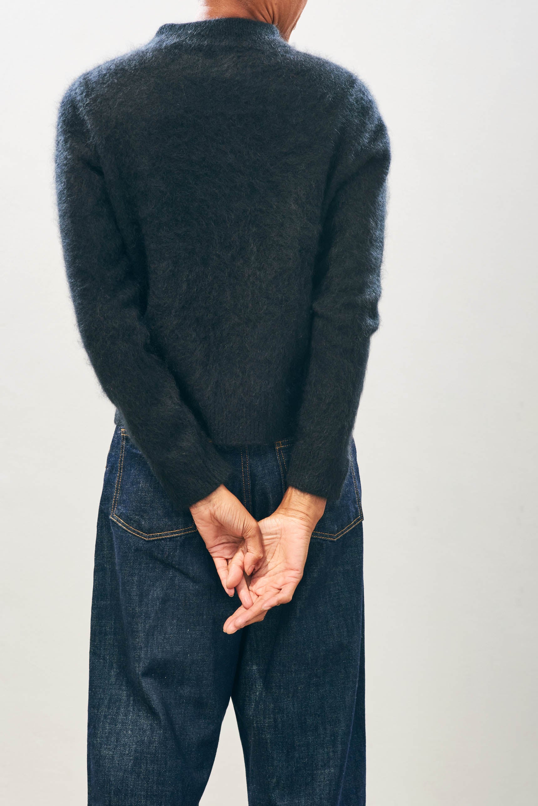 Female model wearing Jumper1234 Cashmere Brushed Turtle in Black facing away from the camera