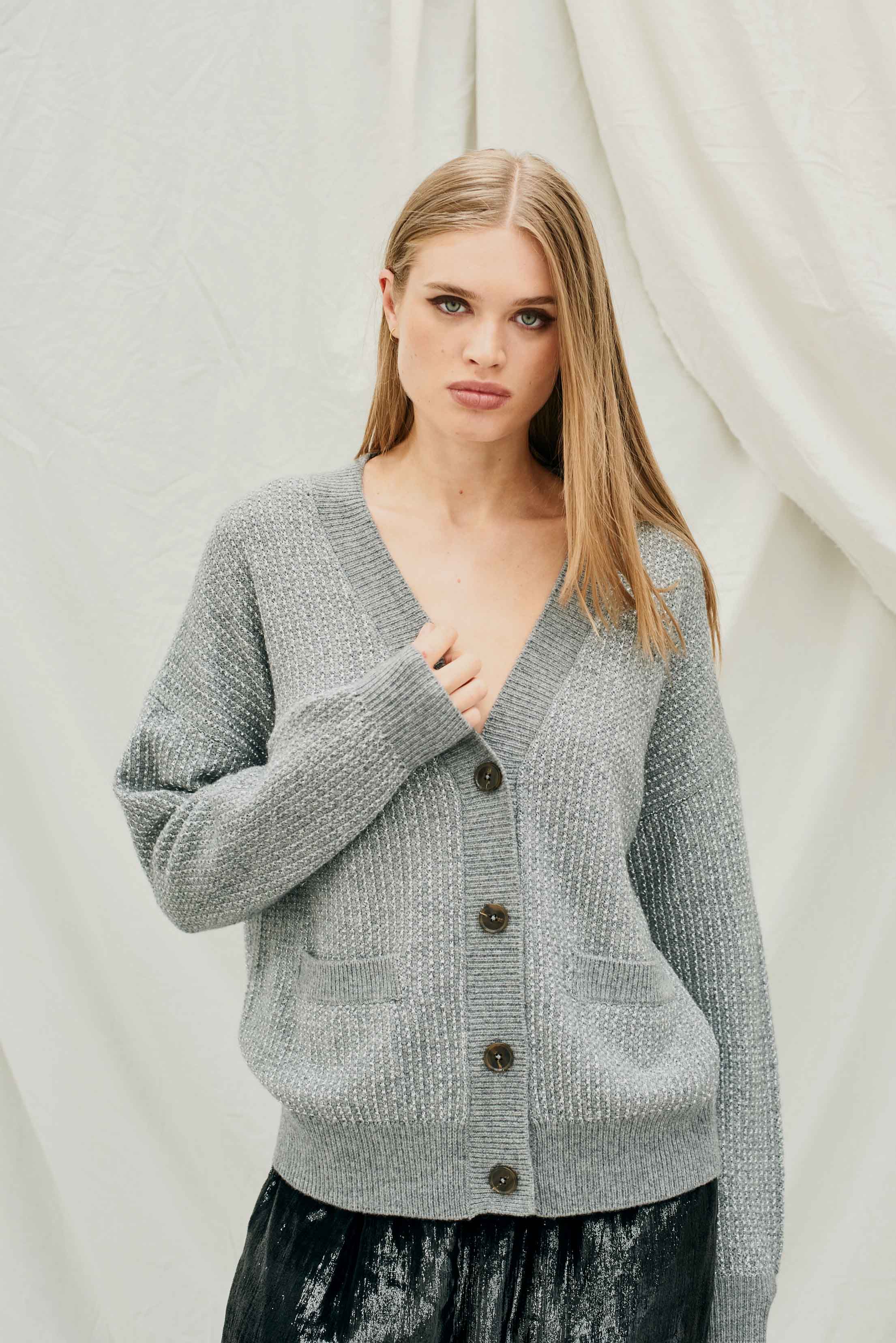 Female model wearing Jumper 1234 Oversize cashmere and wool cardigan in mid grey with silver lurex running through the birdseye texture.