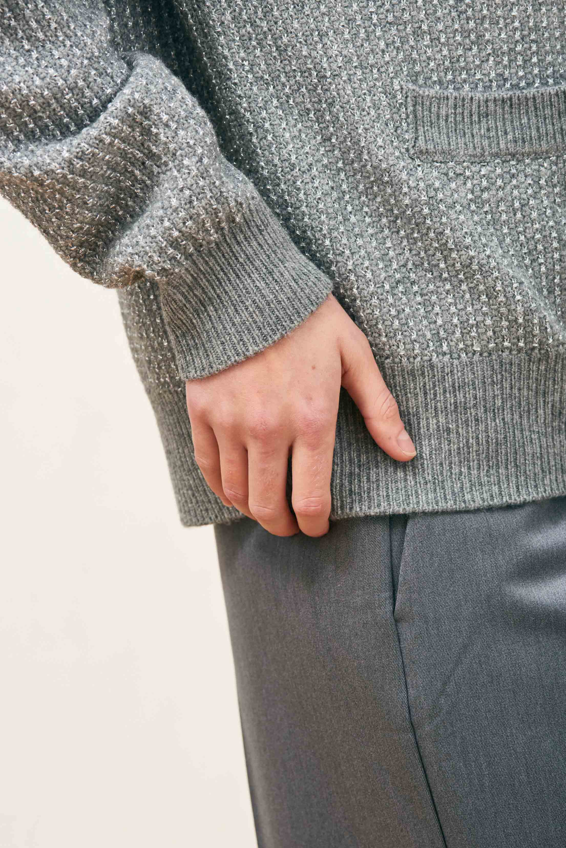 Female model wearing Jumper 1234 Oversize cashmere and wool cardigan in mid grey with silver lurex running through the birdseye texture. Close up.