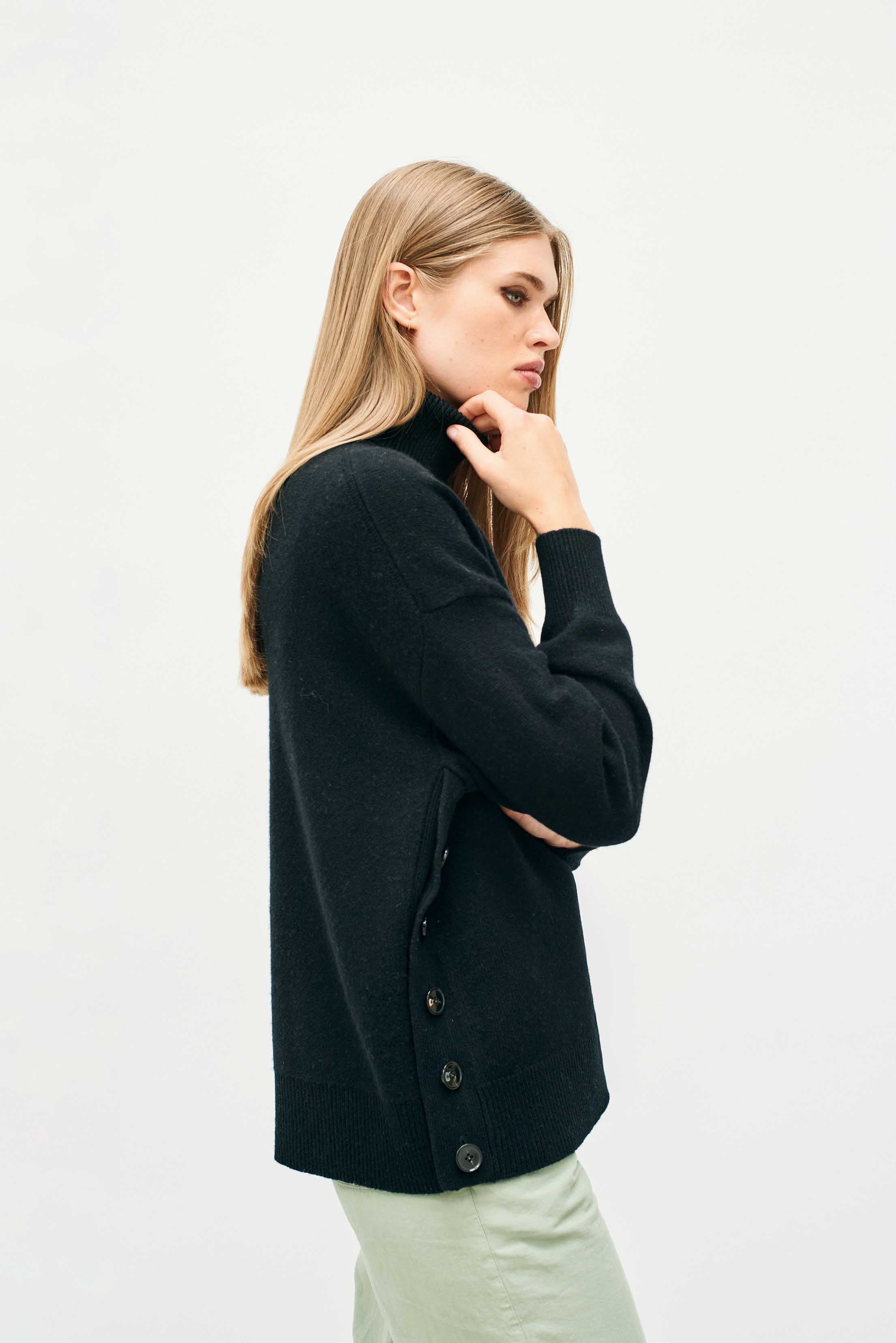 Female model wearing Jumper 1234 Oversize black roll neck in our cashmere and wool blend, heavier weight with a great button detail on one side.