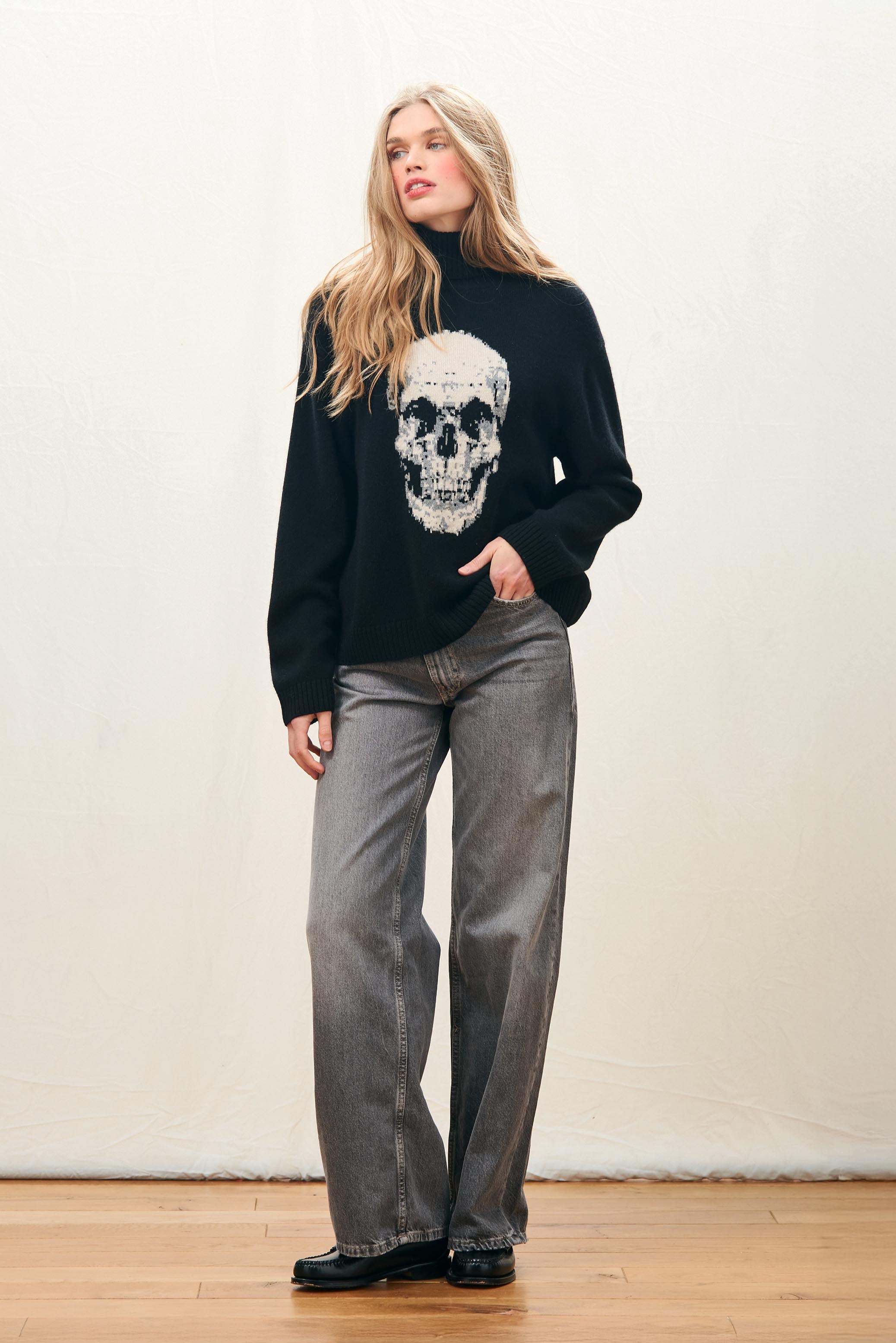 Female model wearing Jumper 1234 Black roll neck jumper in cashmere and wool with a fabulous skull intarsia on the front.