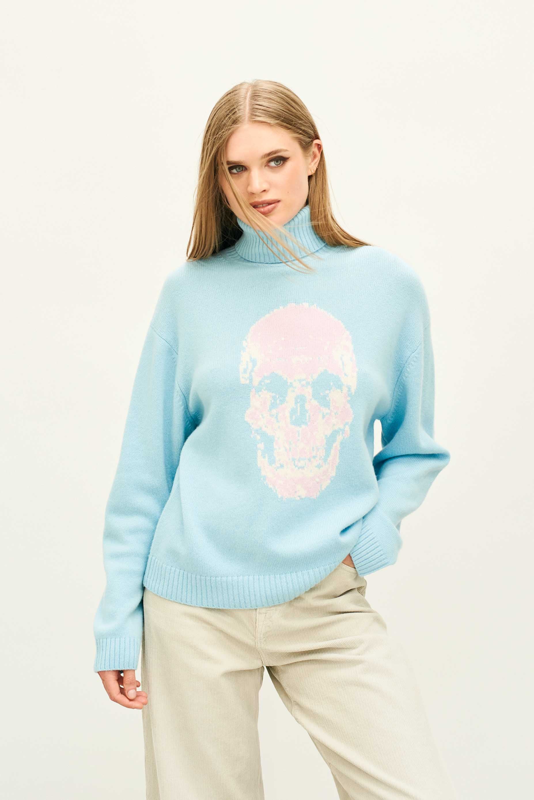 Female model wearing Jumper 1234 Aqua roll neck jumper in cashmere and wool with a fabulous skull intarsia on the front.