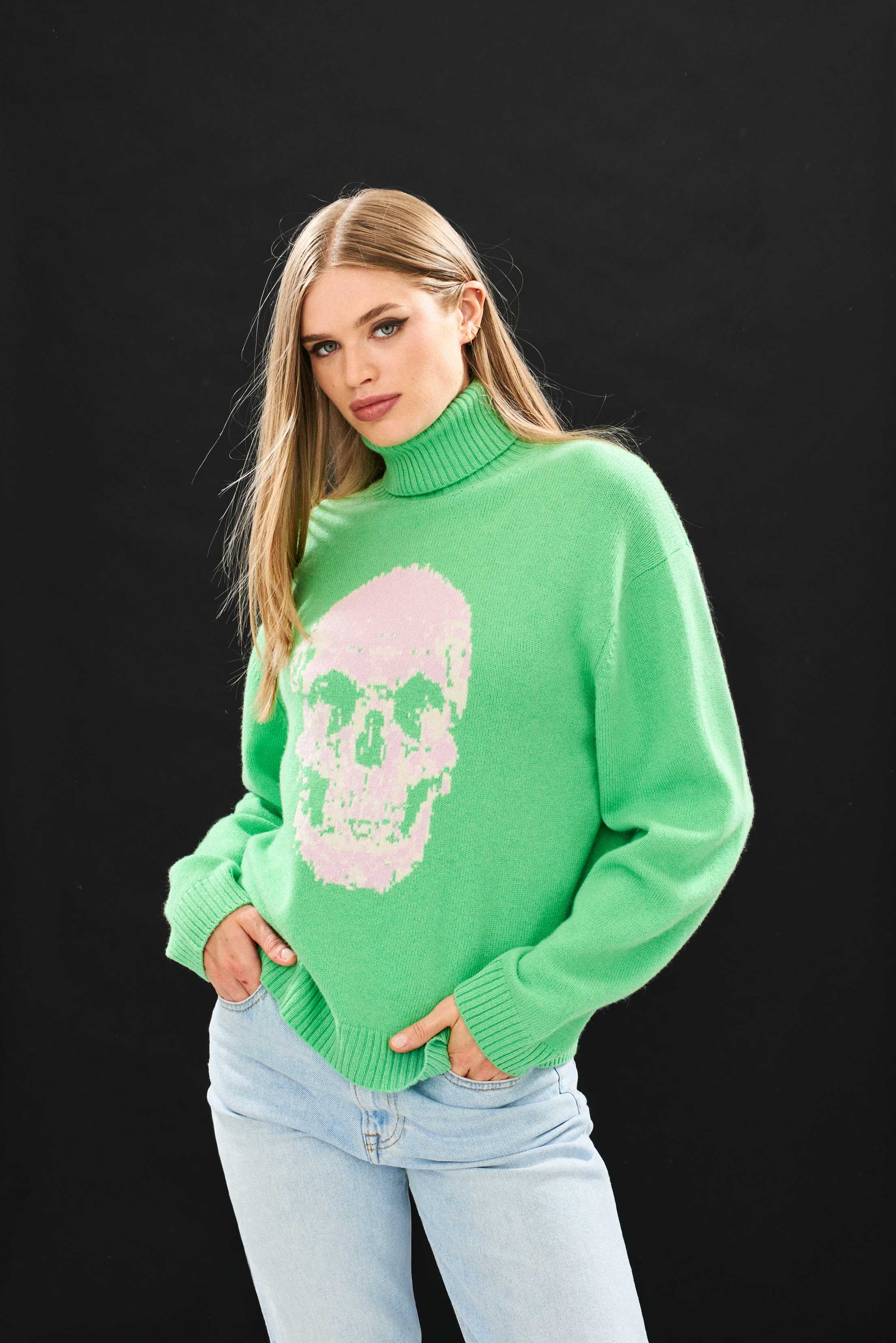 Female model wearing Jumper 1234 Green roll neck jumper in cashmere and wool with a fabulous skull intarsia on the front.
