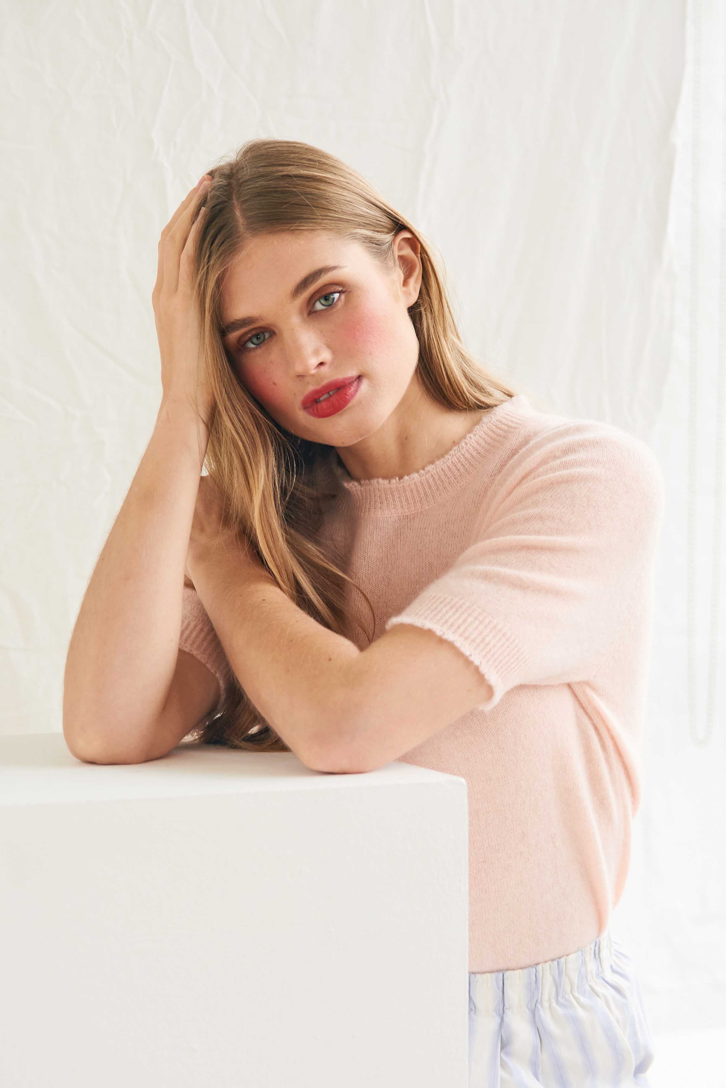 Female model wearing Jumper 1234 Pale pink short sleeve cashmere jumper with 'distressed' ribs.