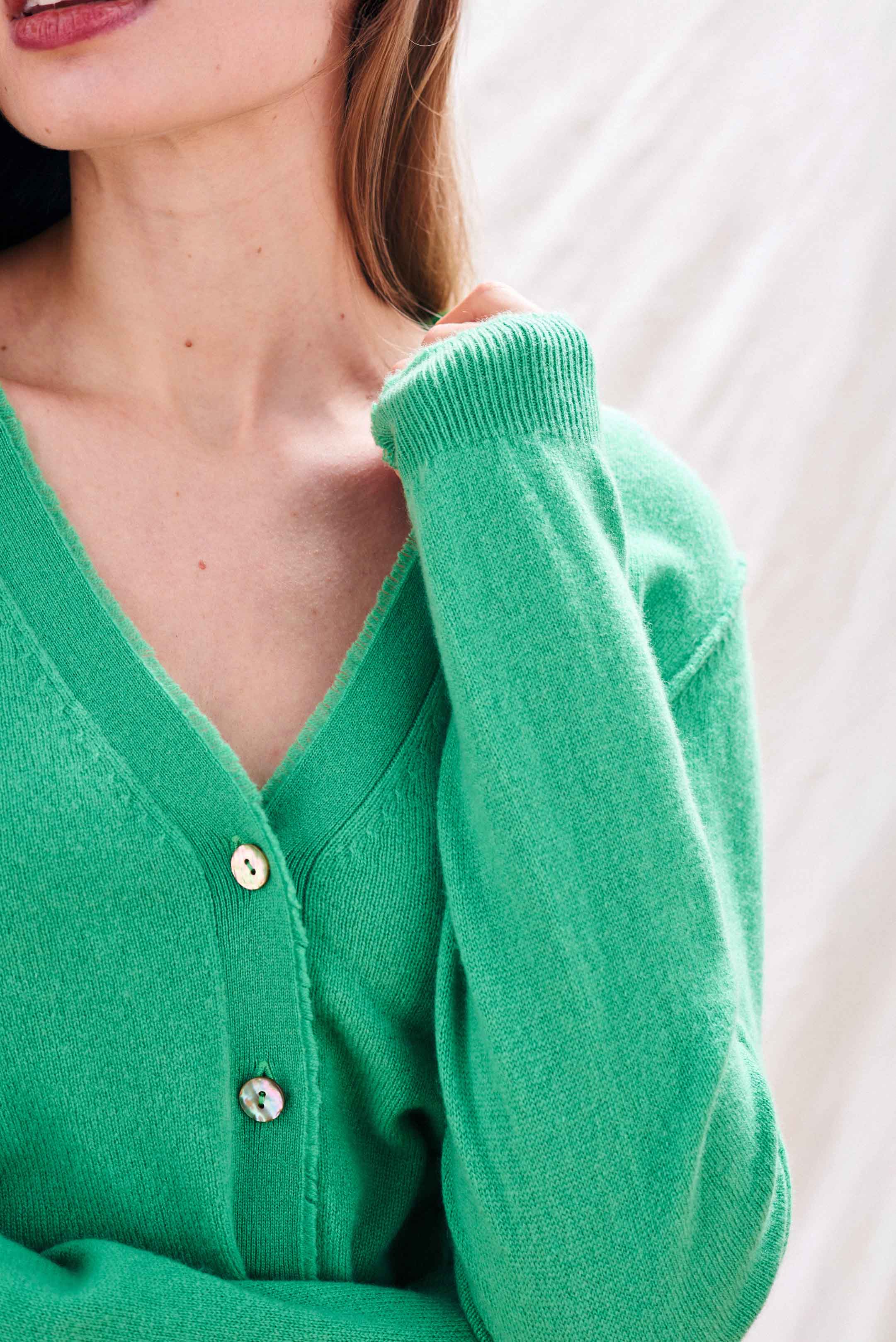 Blonde female model wearing Jumper 1234 Green cashmere vee neck cardigan with 'distressed' ribs