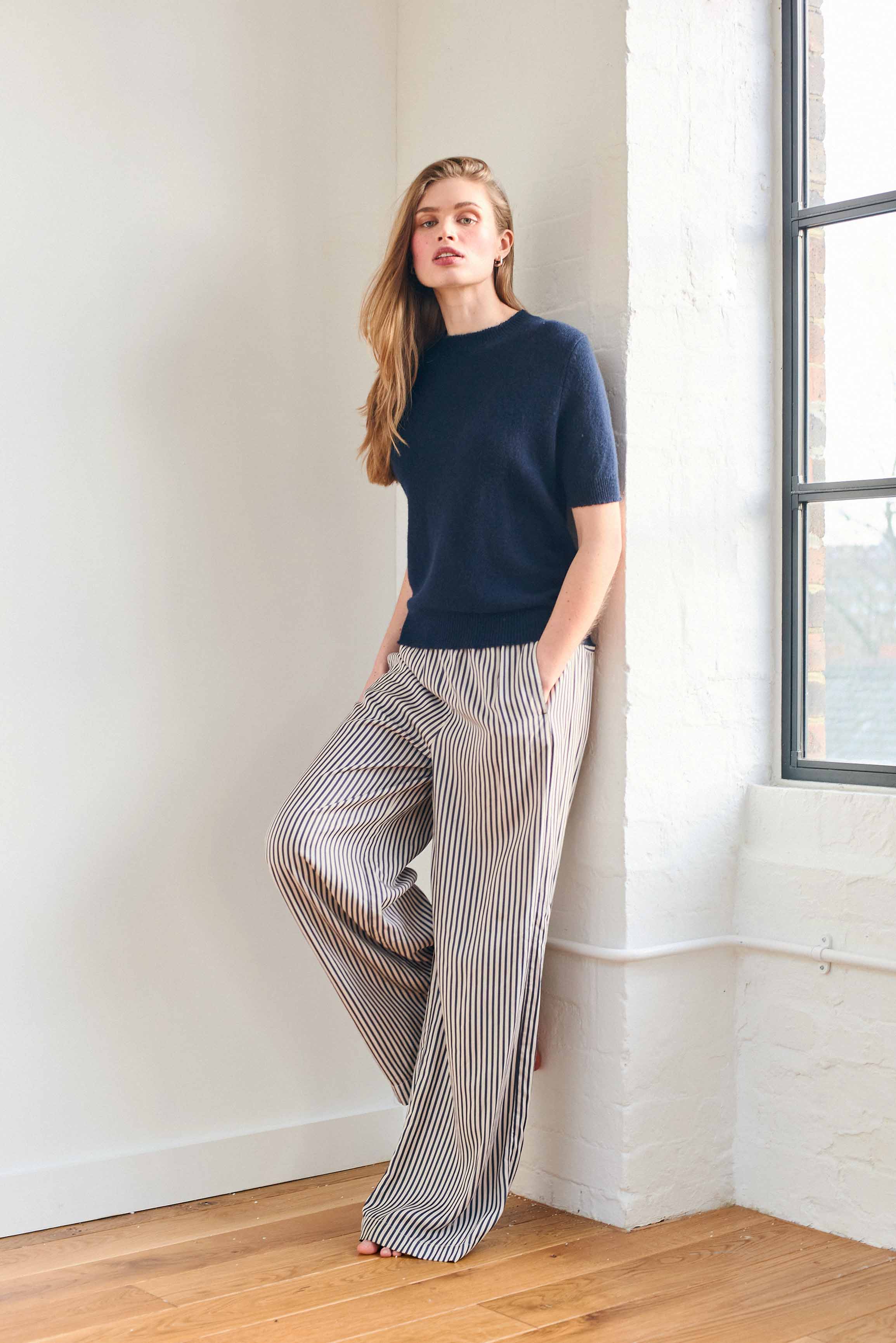 Female model wearing Jumper 1234 Navy short sleeve cashmere jumper with 'distressed' ribs.