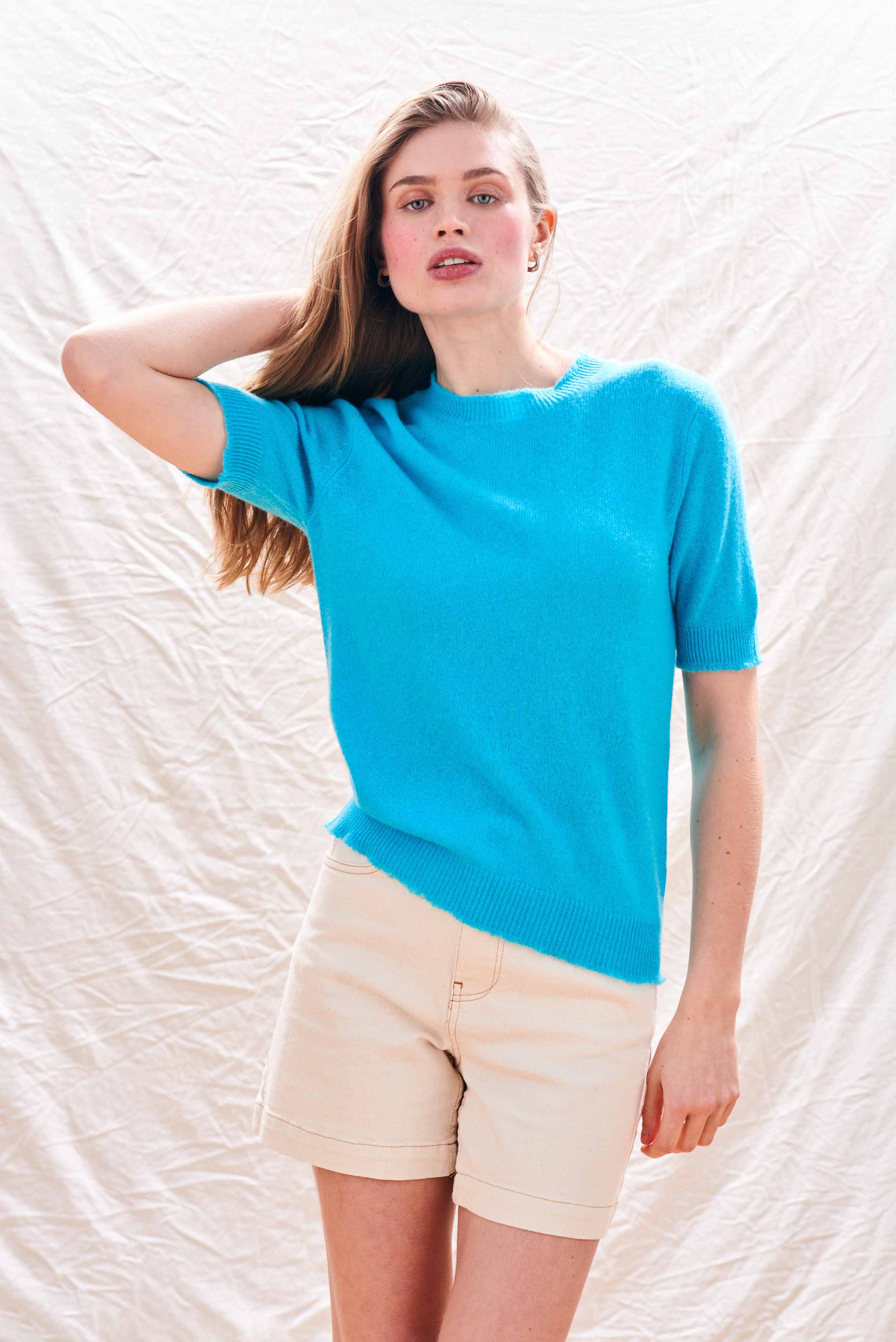 Female model wearing Jumper 1234 Turquoise short sleeve cashmere jumper with 'distressed' ribs.