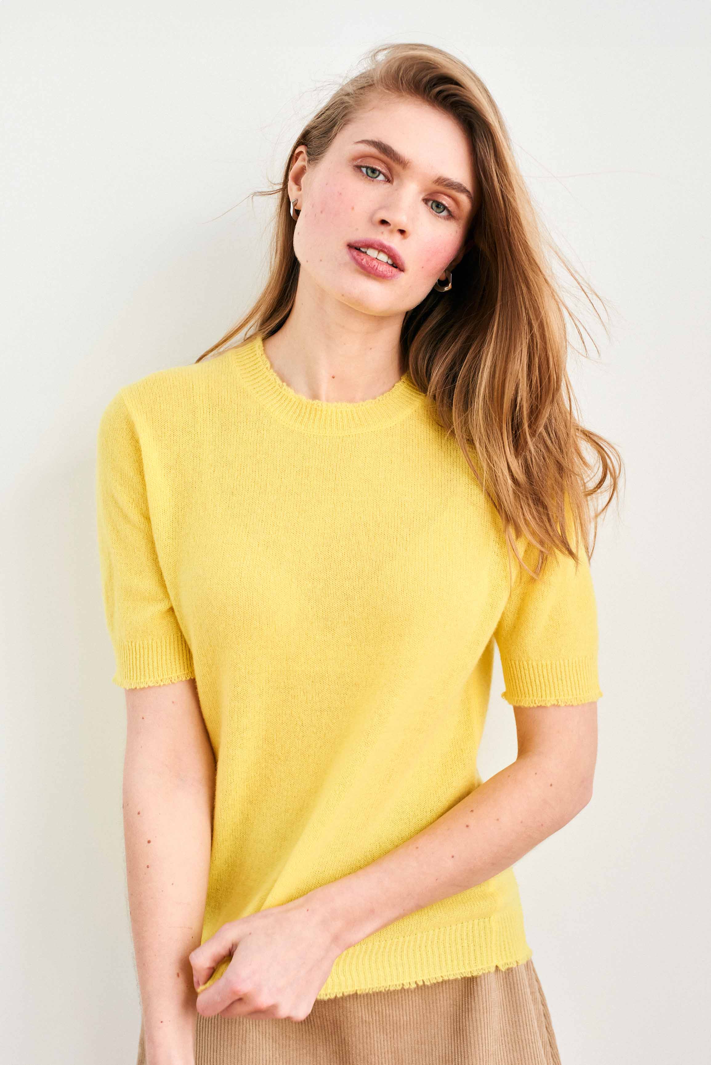 Female model wearing Jumper 1234 Yellow short sleeve cashmere jumper with 'distressed' ribs.