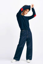Brown haired female model smiling wearing Jumper 1234 cashmere heart patch crew in navy with red heart elbow patches