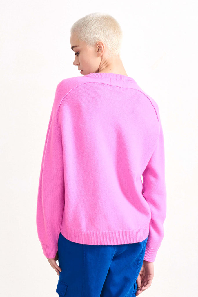 Blonde female model wearing Jumper1234 oversized cashmere crew in Peony facing away from the camera