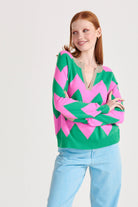 Red haired model wearing Jumper1234 Bright green and peony pink zig zag stripe cashmere jumper, with organic light brown trim open collar