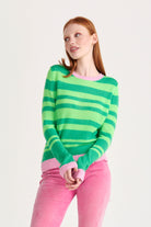 Red haired female model wearing Jumper1234 bright green and neon green stripe crew neck cashmere jumper with rose pink contrast trims