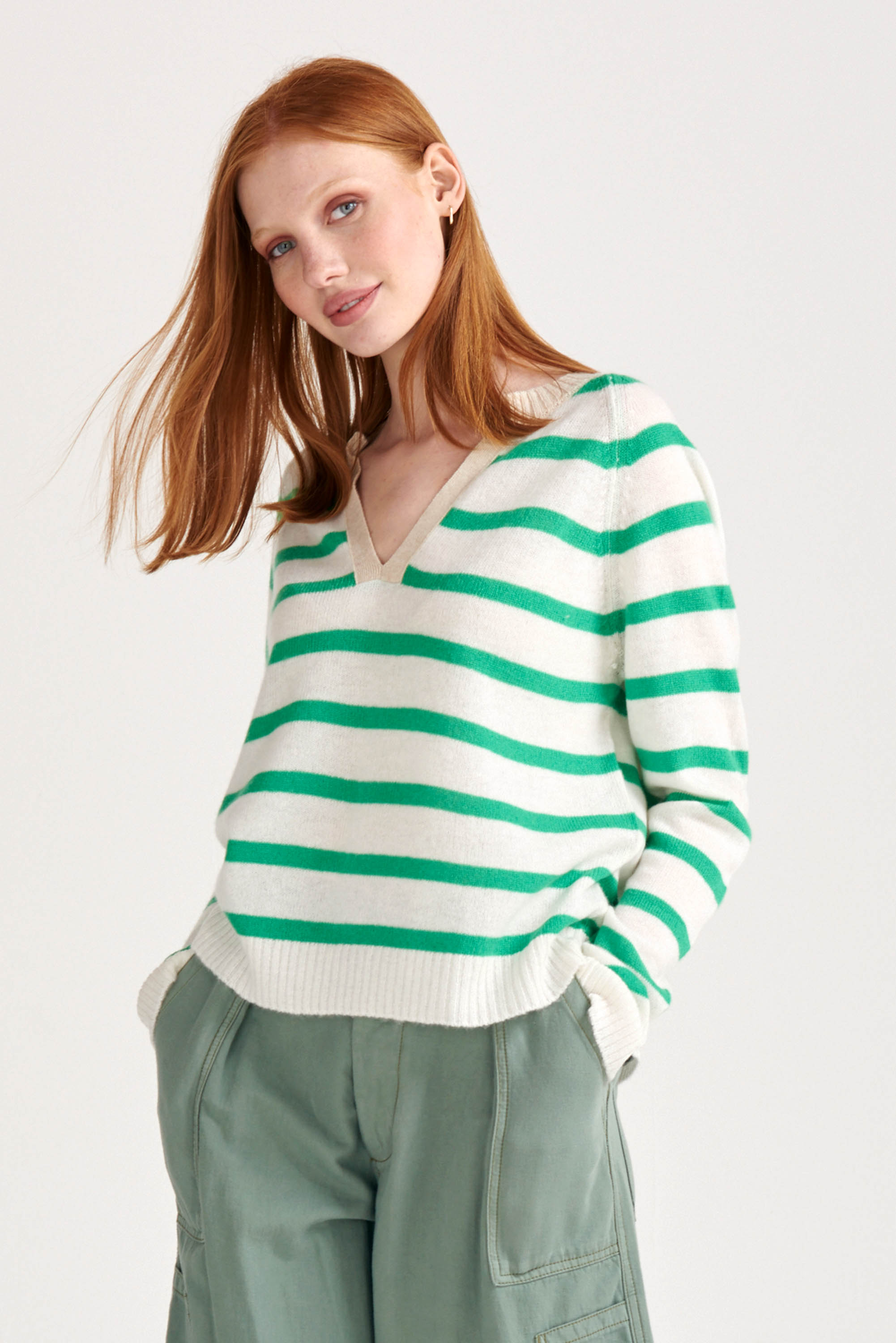 Red haired female model wearing Jumper1234 Bright green and cream stripe cashmere jumper with open collar in contrast oatmeal