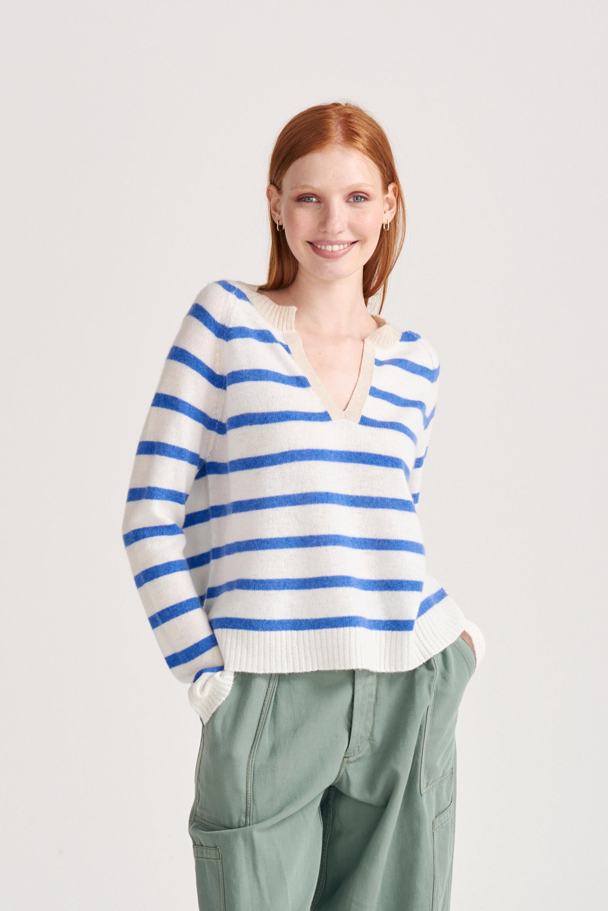 Red haired female model wearing Jumper1234 Periwinkle blue and cream stripe cashmere jumper with open collar in contrast oatmeal