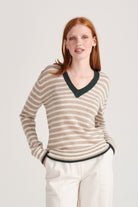 Red haired model wearing Jumper1234 Organic light brown and cream stripe vee neck cashmere jumper with contrast khaki ribs