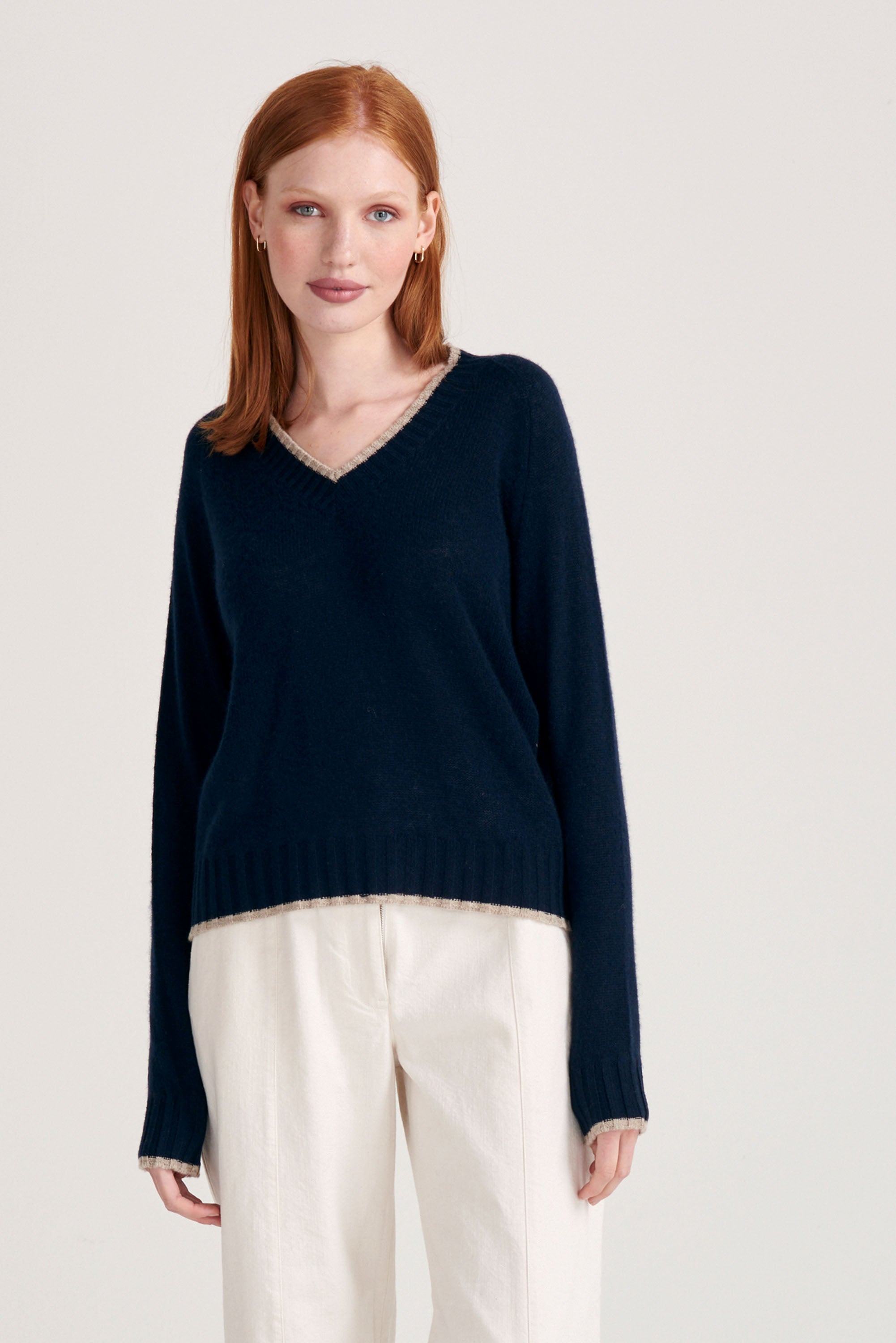 Red haired model wearing Jumper1234 cashmere vee neck jumper in navy with organic light brown tipping