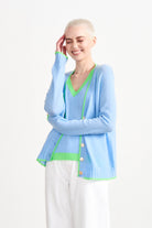 Blonde female model wearing Jumper1234 Wedgewood blue cashmere vee neck cardigan with neon green tipping