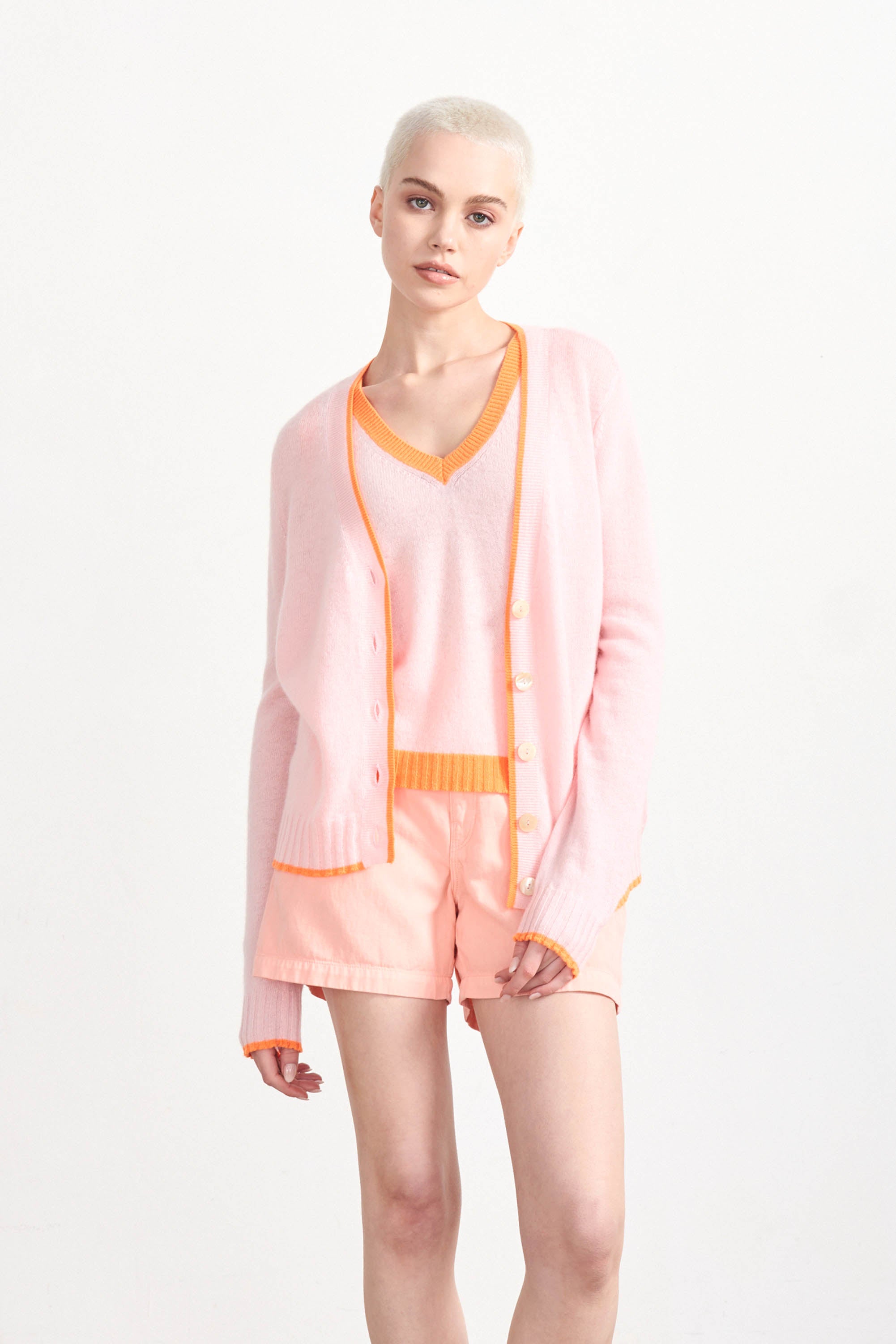 Blonde female model wearing Jumper1234 Pale pink cashmere vee neck tank with contrast neon orange ribs
