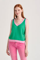 Red haired female model wearing Jumper1234 Bright green cashmere vee neck tank with contrast rose pink ribs