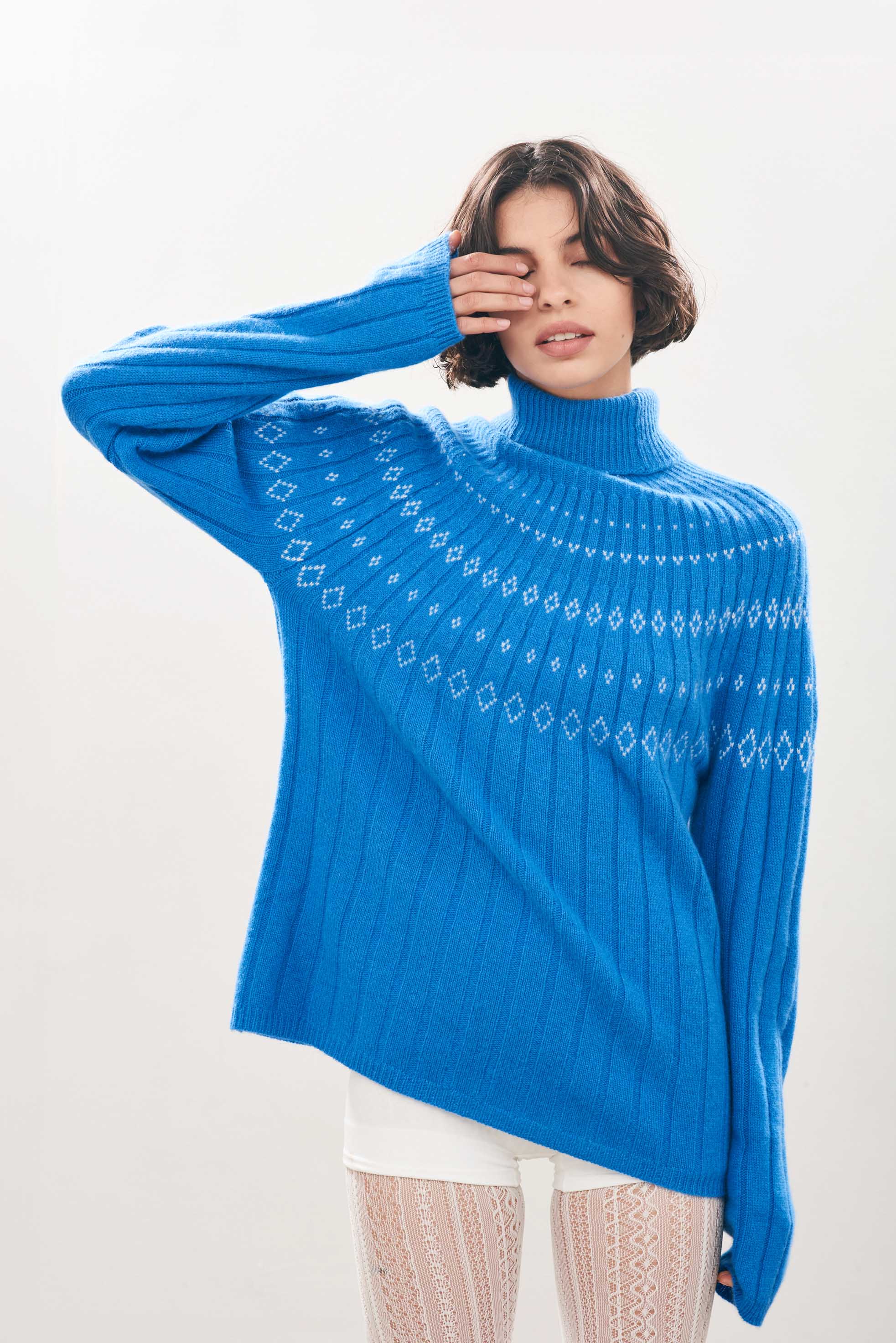 Female model wearing Jumper1234 Cashmere Rib Ski Roll Collar in Sky blue and Cream with fair isle pattern on front and back yolk 