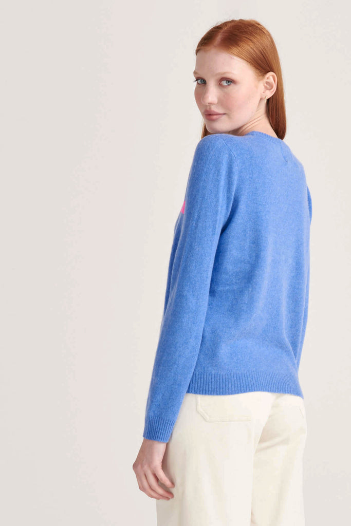 Ginger female model wearing Jumper1234 "Sacre Blue" periwinkle cashmere crew facing away from the camera