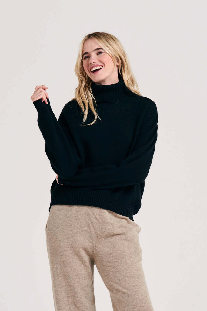 Blonde female model wearing Jumper1234 oversized cashmere roll collar in black