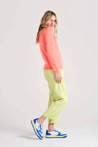 Blonde female model wearing Jumper1234 neon coral cashmere roll neck