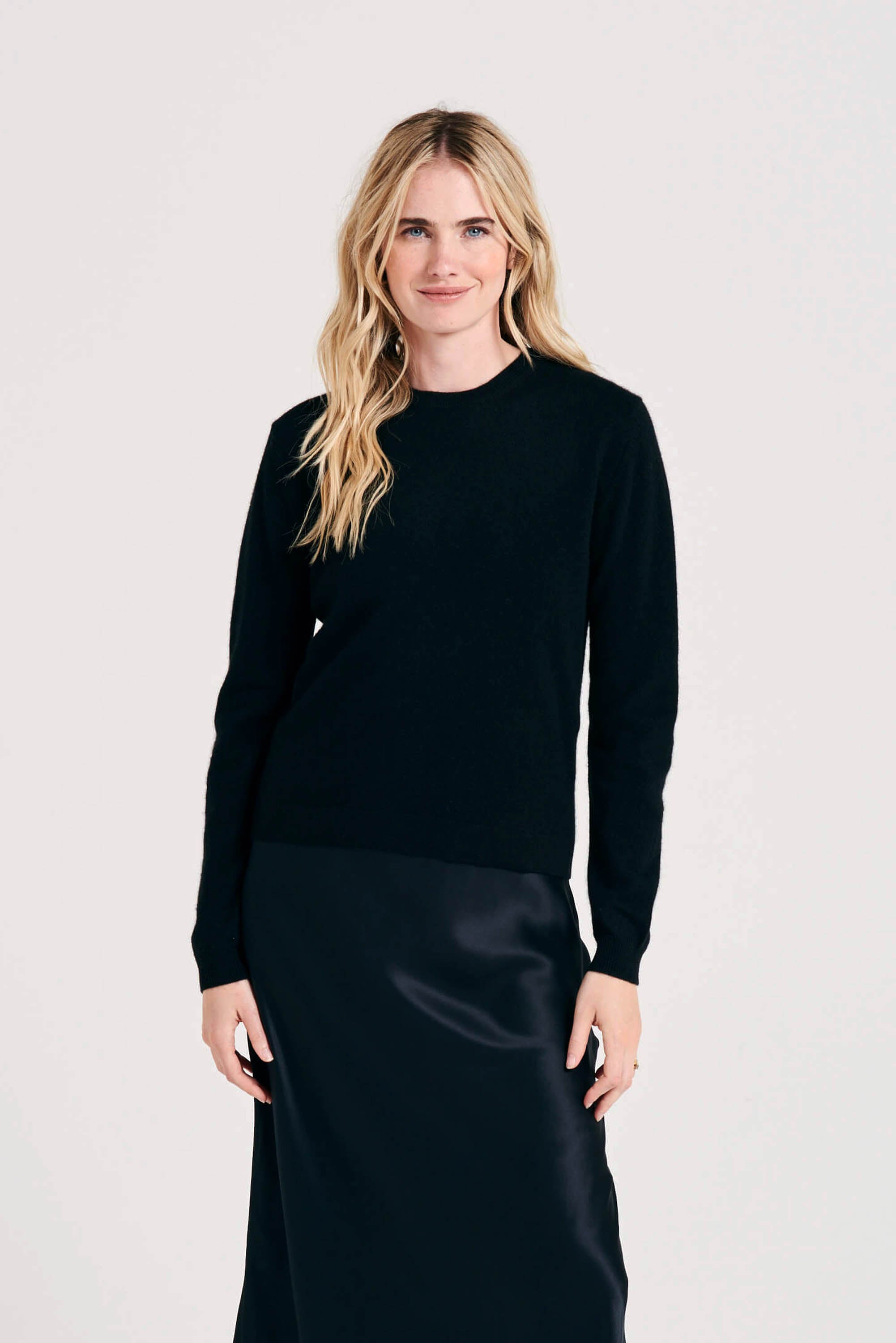 Blonde female model wearing Jumper1234 black cashmere crew neck with mid grey heart patch details on the elbows