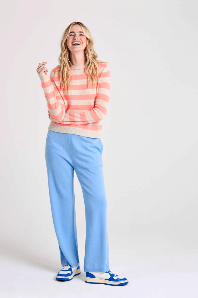 Blonde female model wearing Jumper1234 stripe cashmere crew in oatmeal and neon coral