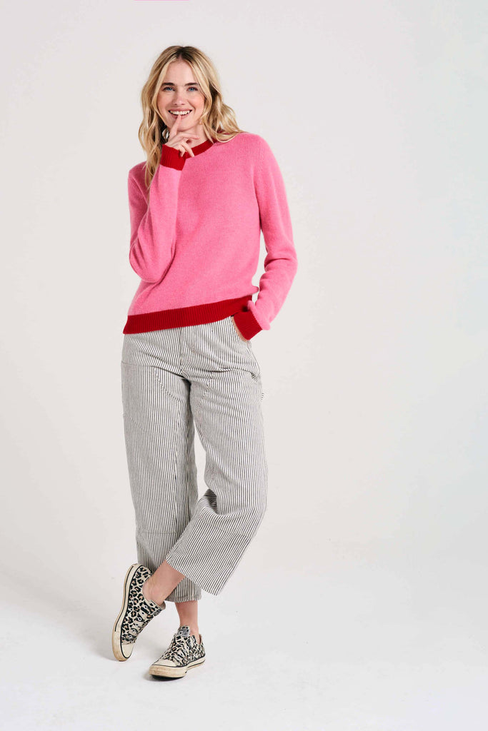 Blonde female model wearing Jumper1234 candy pink cashmere crew neck with red ribs