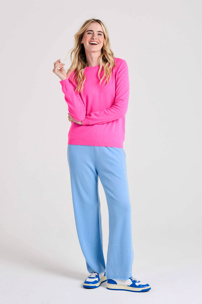 Blonde female model wearing Jumper1234 hot pink cashmere crew with split detail at the wrists and welt