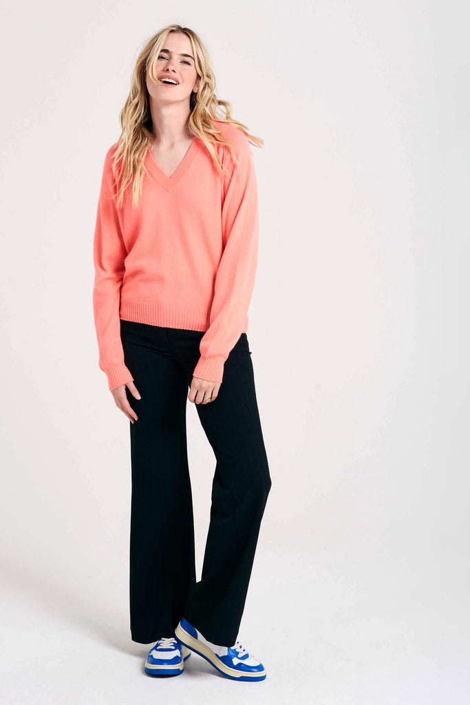 Blonde female model wearing Jumper1234 neon coral raglan cashmere vee neck jumper
