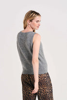 Blonde female model wearing Jumper1234 lightweight cashmere tank in mid grey facing away from the camera
