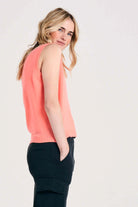 Blonde female model wearing Jumper1234 lightweight cashmere tank in neon coral