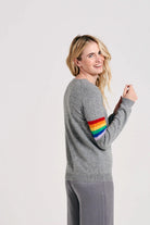 Blonde female model wearing Jumper1234 Rainbow arms cashmere crew in mid grey facing away from the camera
