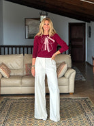 Gayle Rinkoff wearing Jumper1234 Burgundy classic fit crew neck jumper with folklore-inspired intarsia bow in pink and cream