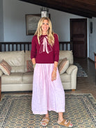 Gayle Rinkoff wearing Jumper1234 Burgundy classic fit crew neck jumper with folklore-inspired intarsia bow in pink and cream