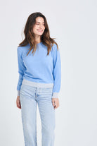 Brown haired female model wearing Jumper1234 wedgewood blue cashmere crew neck jumper with pale blue contrast ribs