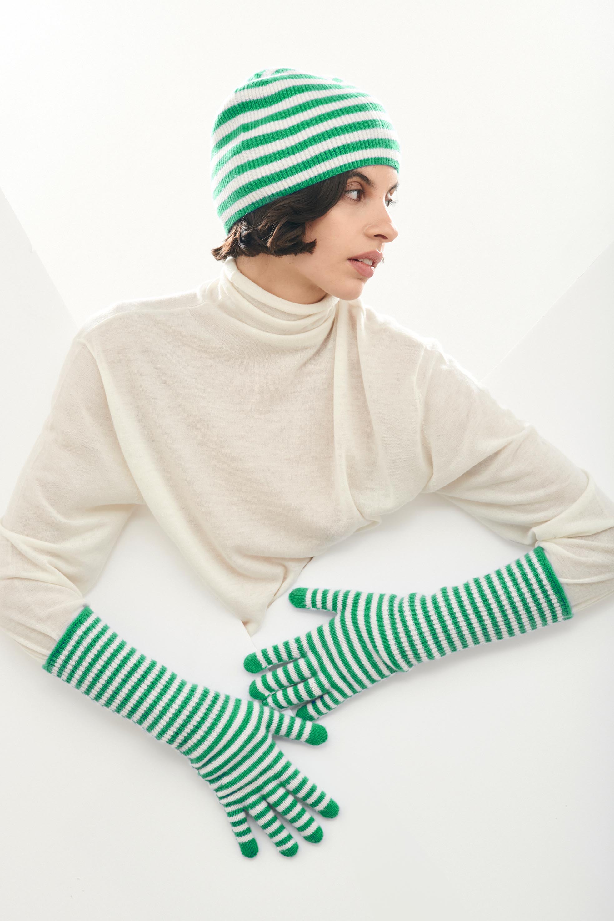 Female model wearing Jumper1234 Cashmere Narrow Stripe Rib Beanie in Bright Green and Cream
