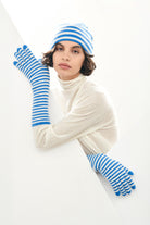 Female model wearing Jumper1234 Cashmere Narrow Stripe Rib Beanie in Sky and Cream