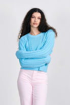 Brown haired female model wearing Jumper1234 Opal cotton aran crew neck jumper with a ribbon tie back