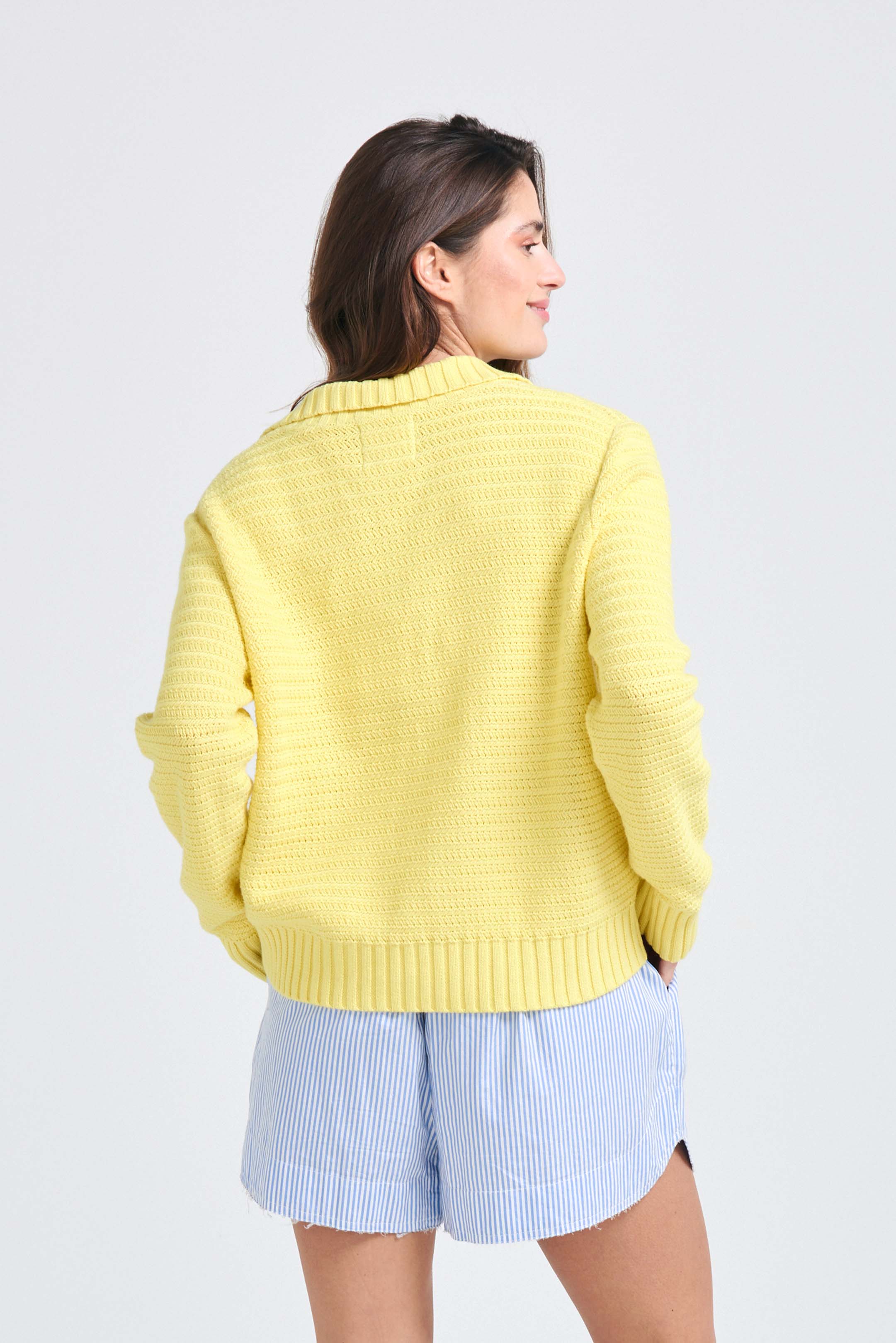 Brown haired female model wearing Yellow cotton jumper with a collar in a fabulous all over herringbone stitch facing away from the camera