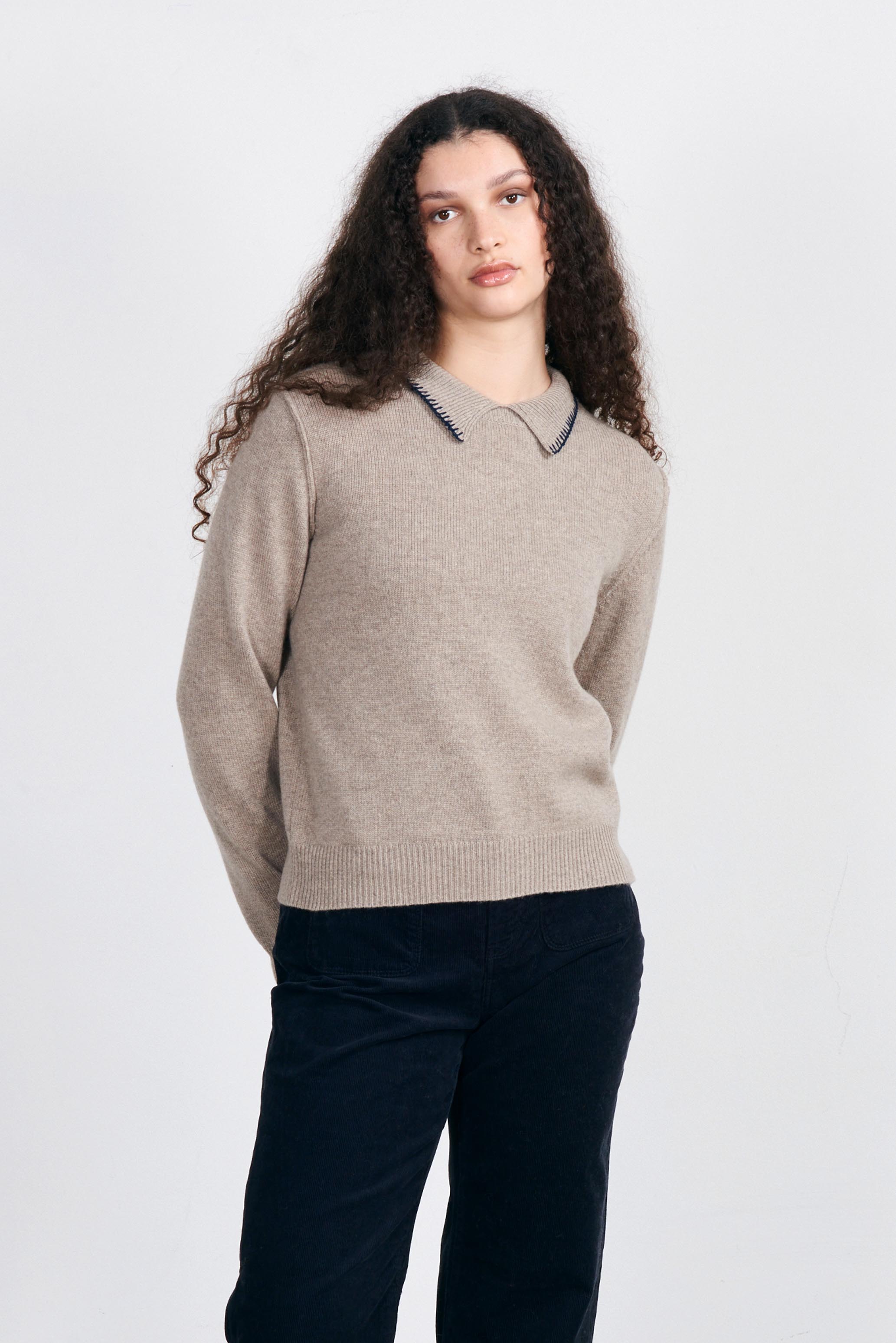 Model wearing Jumper1234 Heavier weight cashmere jumper with a collar in organic light brown with contrast navy blanket stitch detail