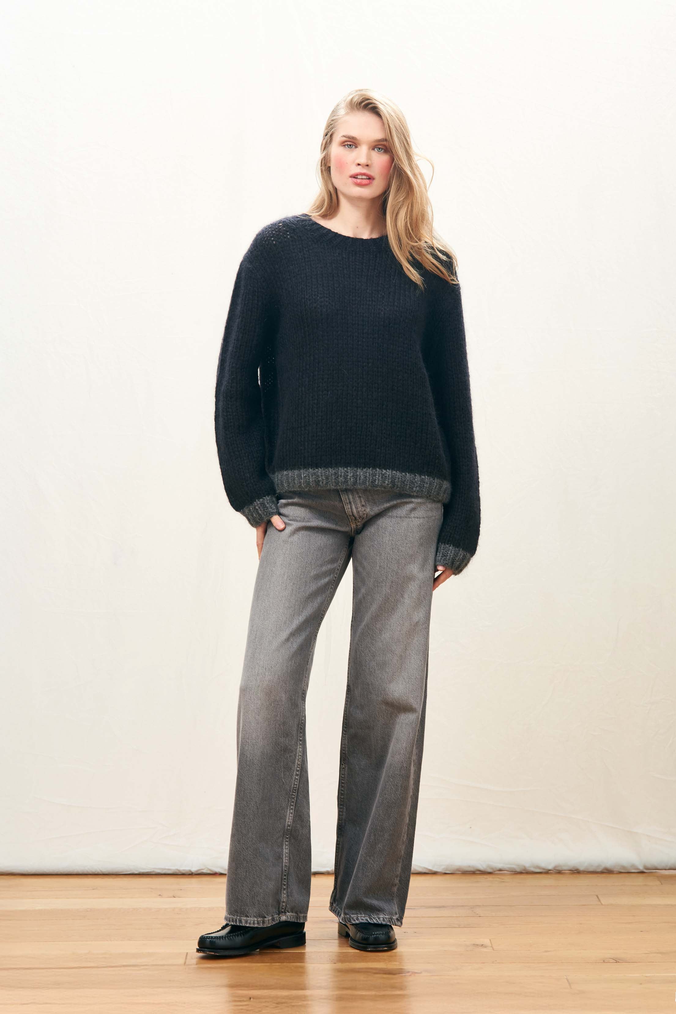 Female model wearing Jumper 1234 hand knitted mohair and wool blend hand knitted crew neck jumper in black with charcoal tipping.