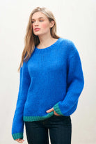 Female model wearing Jumper 1234 hand knitted mohair and wool blend hand knitted crew neck jumper in blue with green tipping.