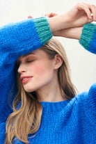 Female model wearing Jumper 1234 hand knitted mohair and wool blend hand knitted crew neck jumper in blue with green tipping close up.